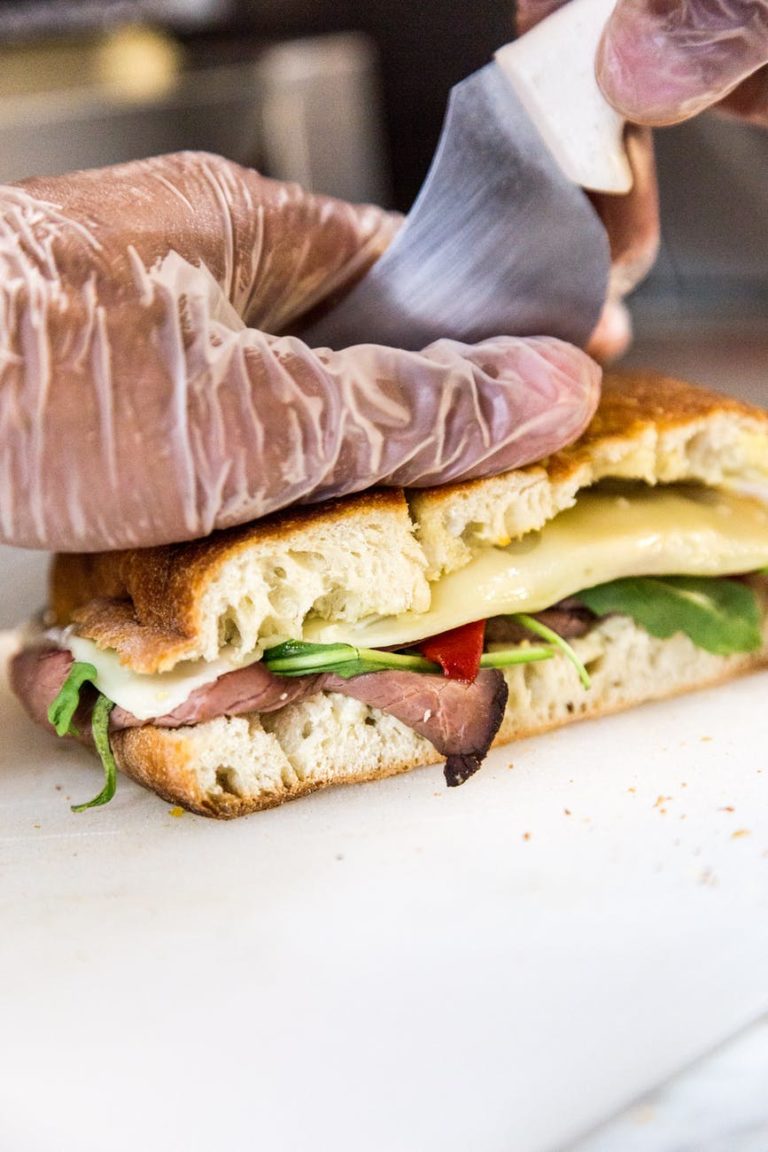 person slicing sandwich bread