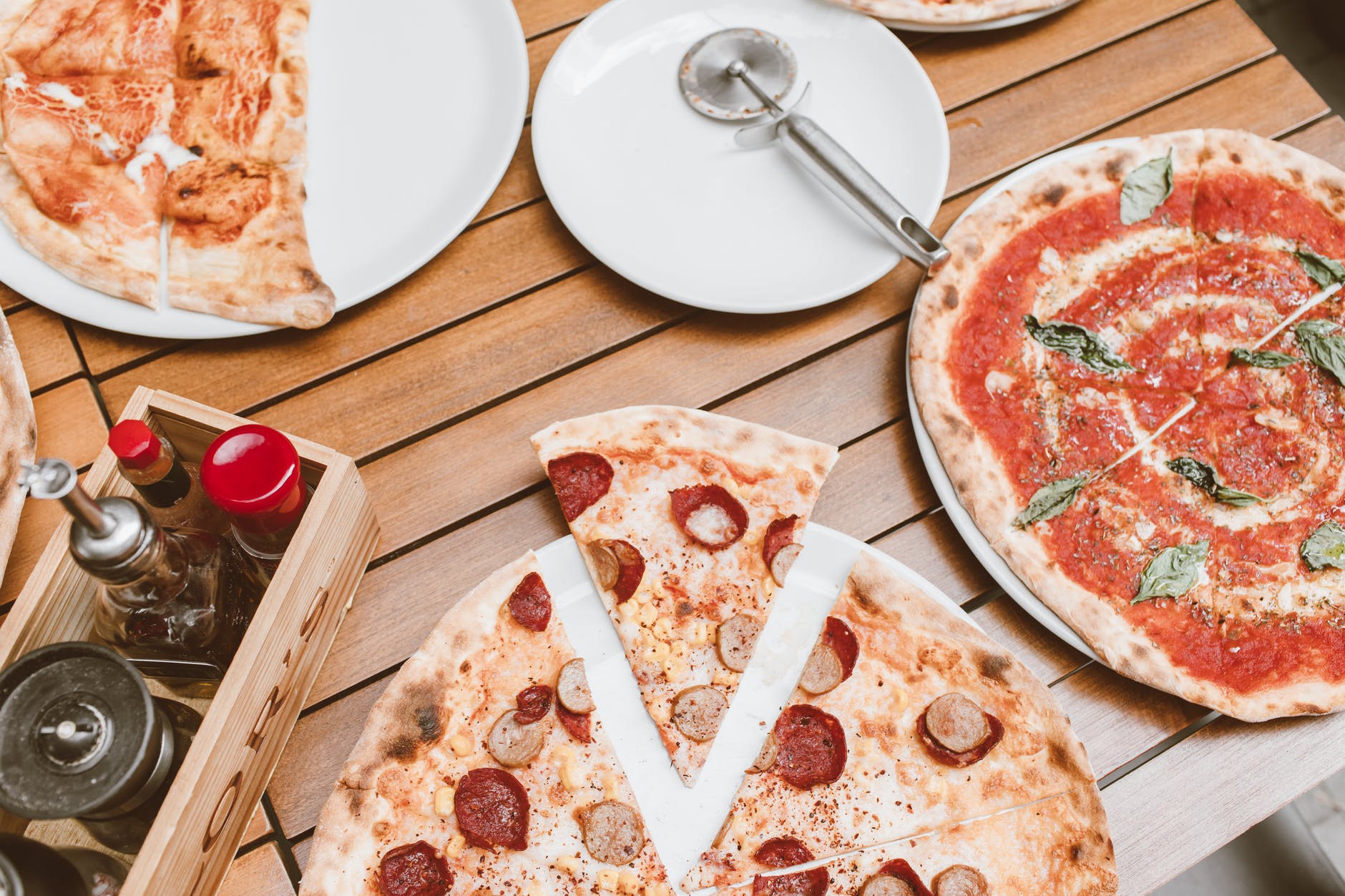 high angle shot of pizzas on wooden table