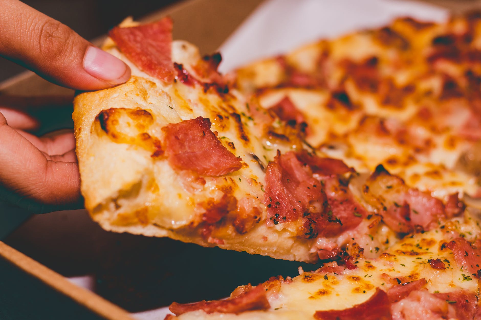 close up photo of person holding pizza