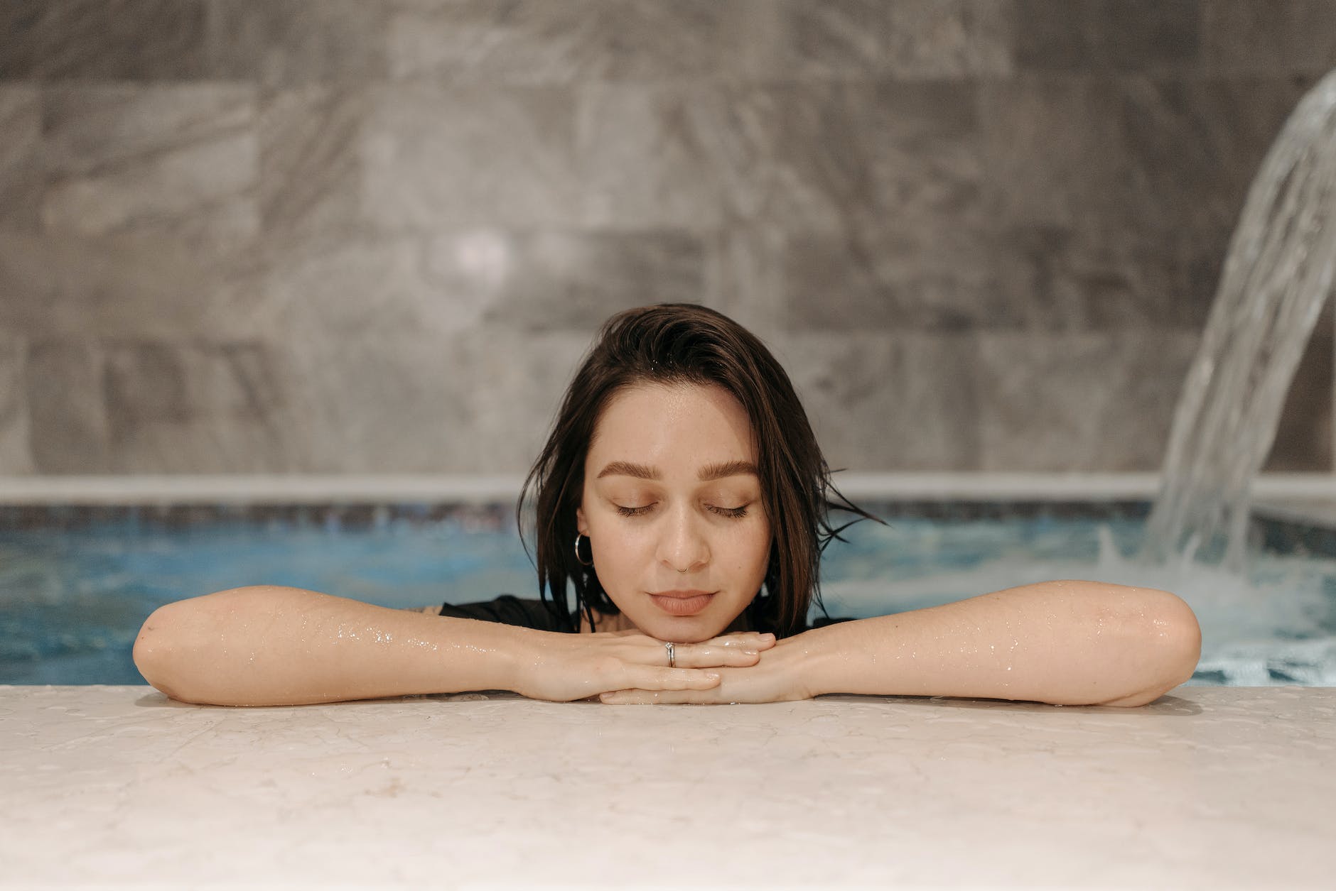 a woman with her eyes closed while in a pool