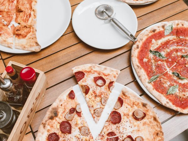 high angle shot of pizzas on wooden table